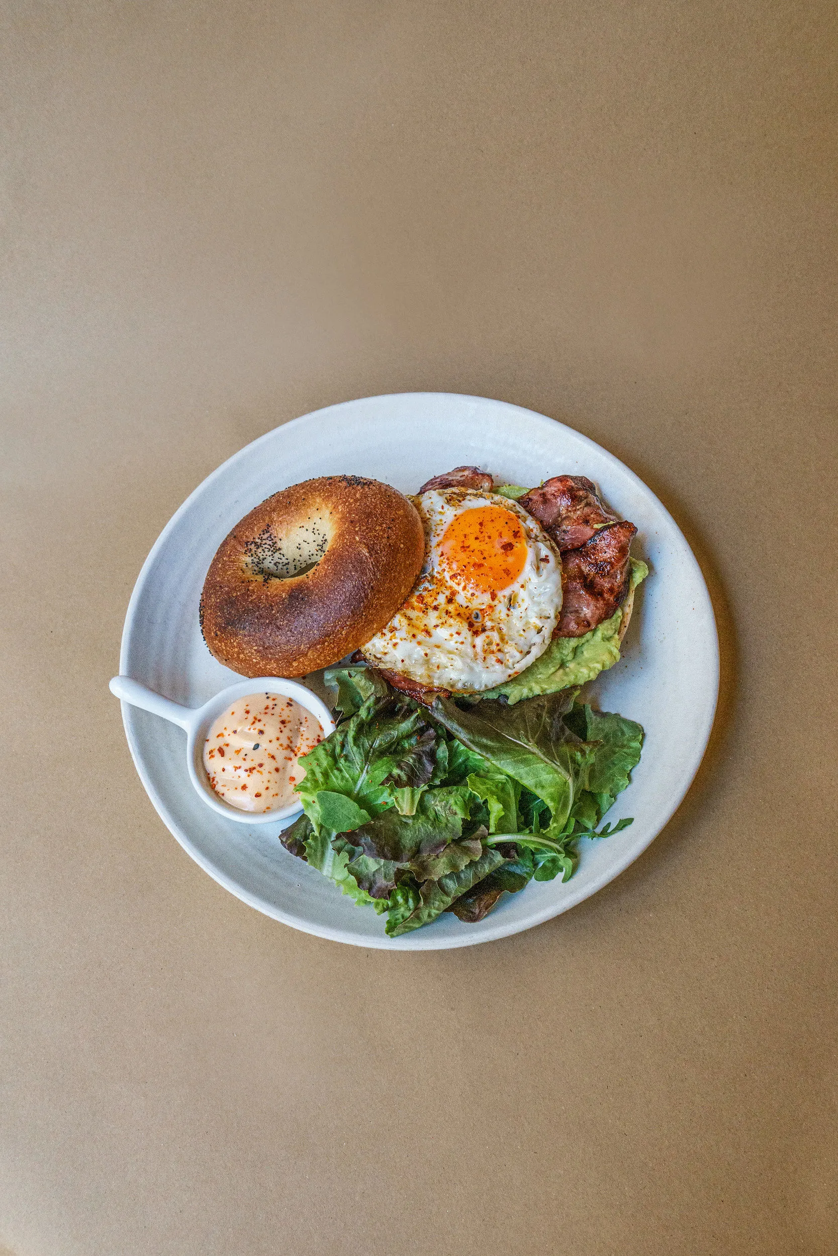Bacon bagel with a fried egg and greens