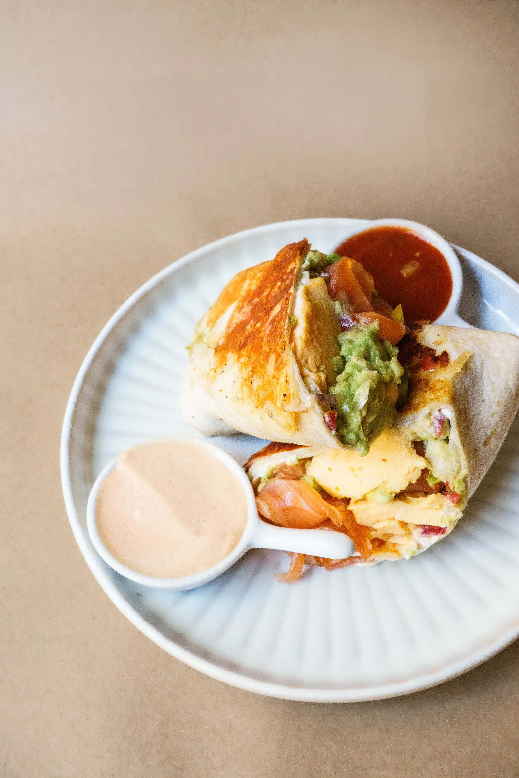 Avo and salmon wrap, cut open, with salsa and chili mayo